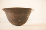 Detail of a vintage African wooden bowl, showing carved lines and a textured patina.