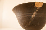 Detail of vintage African wooden bowl with metal repair over prominent crack and carved zig-zag texture.