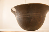Detail of vintage African wooden bowl with silver repair, visible cracks, and incised lines.