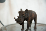 Detailed dark copper texture on the vintage African rhino sculpture's face.