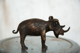 Textured dark copper vintage rhino sculpture, with golden highlights.