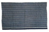 Vintage hand-woven African indigo textile throw with blue and light beige stripes.