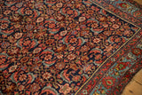 Corner detail of an antique Bijar rug's dense, allover Herati motif in indigo and red.