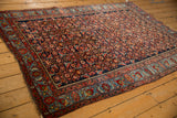 An antique Bijar rug showing its traditional Herati pattern and richly colored multi-band border.