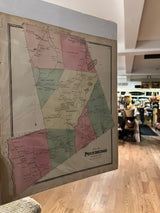 The physical antique map of Pound Ridge shown at an angle, with its colored districts and aged patina.