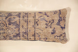 Faded purple geometric pattern on textured beige rug fragment pillow.
