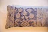 Faded blue geometric pattern on the Reclaimed Rug Fragment Pillow's textured surface.