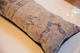 Reclaimed Turkish rug fragment pillow showing beige hand-knotted pile and indigo geometric motifs.