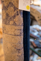 Textured beige vintage rug fragment and smooth navy velvet pillow backing.