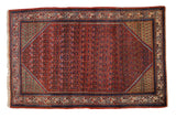 Vintage Arak Sarouk rug with a red allover plant motif, copper-green corner spandrels, and a navy border.