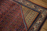 Unusual oxidized copper green corner spandrel showing boteh motifs on a vintage Sarouk rug.