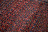 Hand-knotted texture of germinating plant motifs in cherry red and navy on a vintage Arak rug.