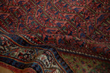 Folded Sarouk rug showing the low pile texture, geometric field, and oxidized copper green border.