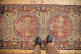 Close perspective of the antique Kerman runner's red pictorial medallions with mythological figures.