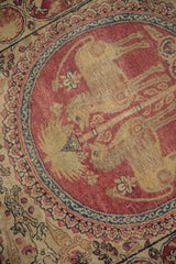 A mythological lion-like figure inside a cochineal red medallion showing its time-softened pile.