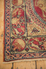 Border detail of an antique Kerman rug with rabbit and dog motifs inside red and ivory cartouches.