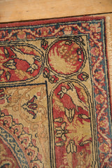 Antique Kerman rug border detail with a rabbit motif in a red and sand colored cartouche.