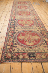 Full length perspective of an antique Kerman runner, emphasizing its column of pictorial medallions.