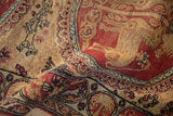 Folded corner of an antique Kerman runner showing its soft, low pile and detailed pictorial designs.