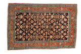 Antique Serapi rug with an allover Herati design, a navy blue field, and terracotta borders.