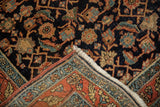 Folded corner of a fine antique Serapi rug revealing the hand-knotted back and Herati pile.