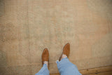 Distressed vintage Oushak rug pile with even wear and faded sand, blue-green tones.