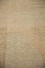 Distressed Oushak rug pile texture with pale sand tones and subtle patina.