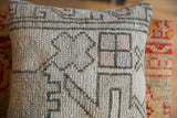 Hand-knotted pile texture showing faded gray, pink, and mint geometric motifs.