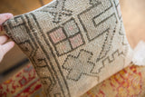 Textured Oushak fragment pillow with light gray geometric pattern, faded pink squares, and wear.