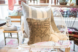 Textured vintage Oushak rug fragment pillow, displaying geometric pattern and faded pink details.