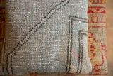Textured surface of the vintage Oushak rug pillow, with muted gray, pink, and mint hues.