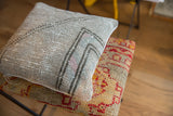 Distressed light gray vintage Oushak fragment pillow with faded pink, mint, and geometric backing.