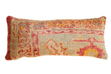 Reclaimed Turkish rug fragment lumbar pillow, geometric pattern in muted red, yellow, and blue.