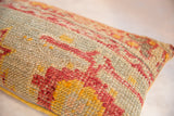 Distressed hand-knotted texture of the vintage Turkish lumbar pillow, with muted red and golden geometric patterns.