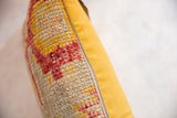 Distressed texture of vintage Turkish rug fragment pillow, red, gold, beige weave, yellow backing.