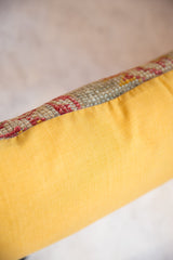 Hand-woven vintage Turkish rug fragment with red patterns and yellow backing.