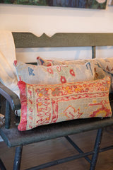 Row of textured vintage Turkish rug fragment pillows, vibrant red and orange patterns.
