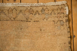 Close-up on the distressed Oushak's corner, showing textured wear and secured ivory fringe.
