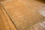 Angled perspective of a distressed Oushak runner with a pale gold and faded raspberry palette.