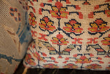 Stylized red and gold floral motifs on a hand-knotted vintage Kurdish rug fragment pillow.