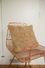 Vintage Turkish rug fragment pillow, highlighting textured weave in faded orange and beige.