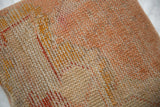 Detailed textured weave of the vintage Turkish rug fragment pillow, featuring distressed beige, orange, and red tones.