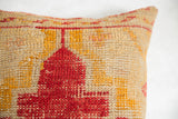 Hand-woven texture of antique rug fragment pillow, red, yellow geometric patterns.