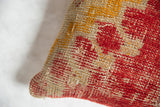 Hand-woven texture of antique rug fragment pillow featuring rich red, soft beige, and ochre yellow.