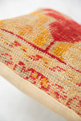 Hand-knotted texture of antique rug fragment pillow, with red, yellow geometric patterns, and beige backing.