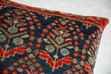 Detail of hand-knotted Vintage Rug Fragment Throw Pillow with deep blue, ruby red, tan motifs.