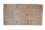 Distressed vintage Oushak rug with geometric and floral patterns in soft silver, copper, and ivory.