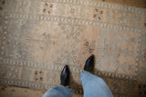 The low, hand-knotted pile of a vintage distressed Oushak rug in soft silver and ivory.