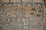 Evenly worn pile on a distressed vintage Oushak rug, with silver and saffron floral designs.