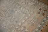 Wide banded floral border of a vintage Oushak rug showing wear down to the knot heads.